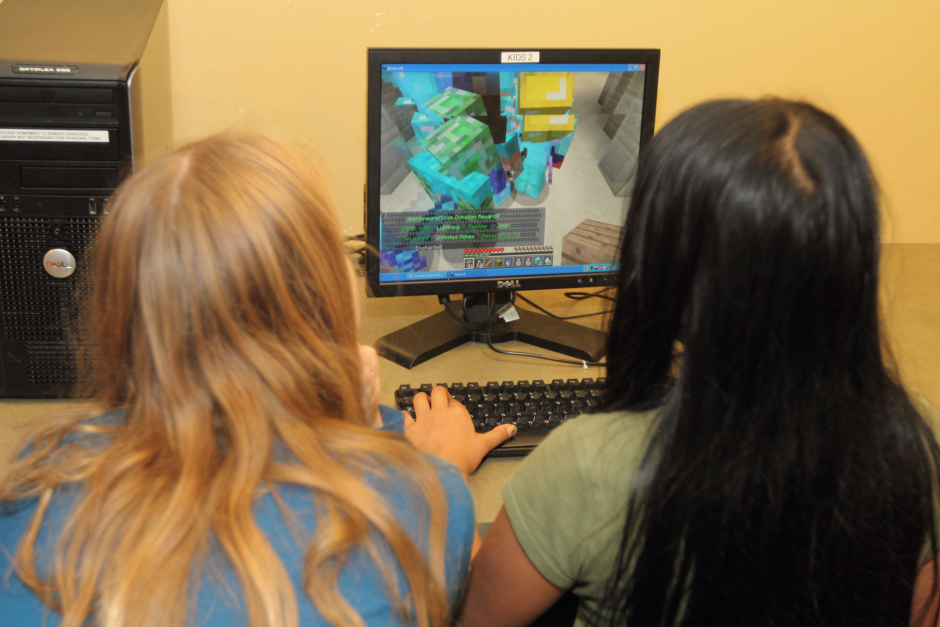 2 children playing on a computer.